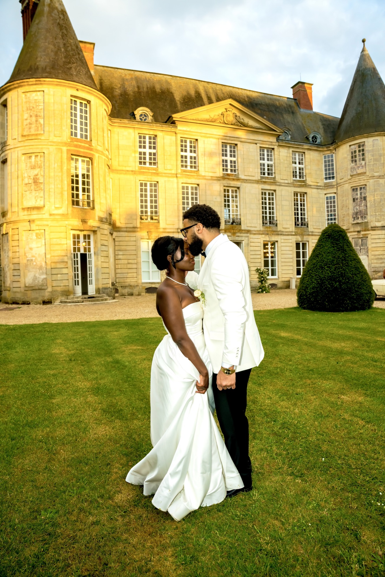 A couple in front of a château at golden hour