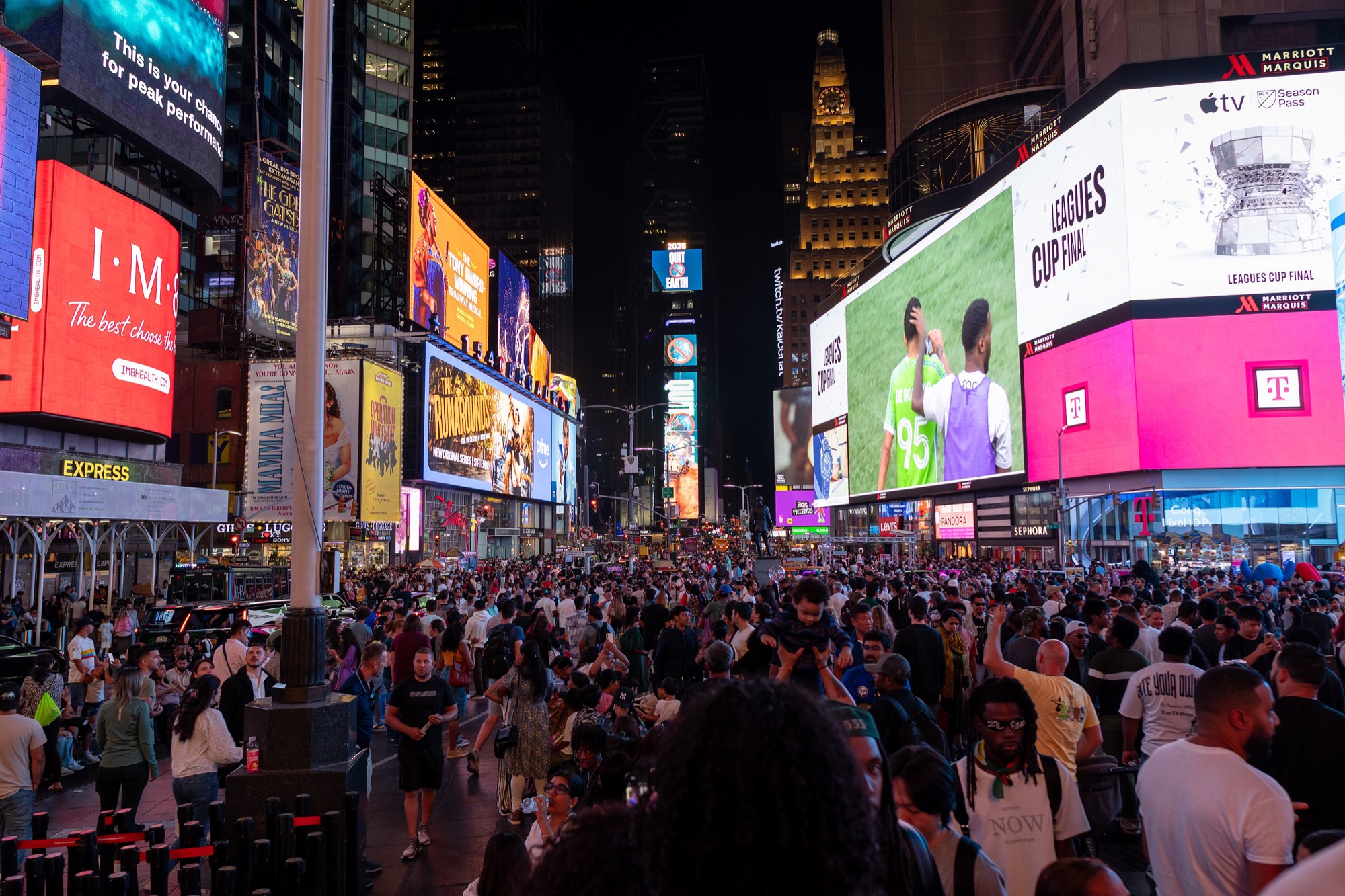 Crowds under the billboards of Times Square at night