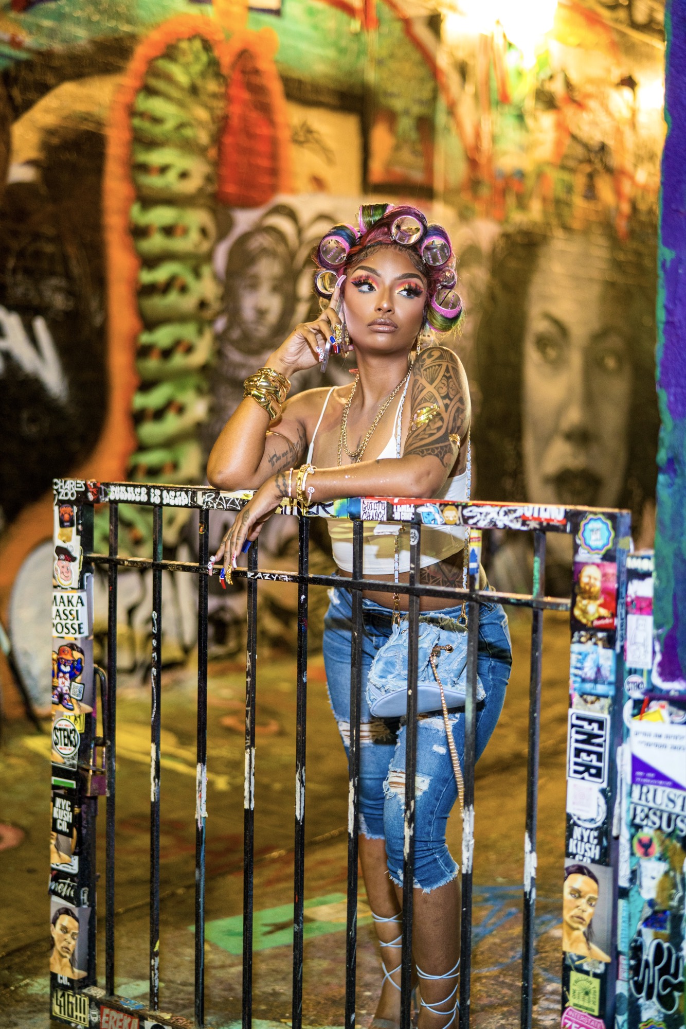 A model in denim and gold jewellery against a graffiti wall